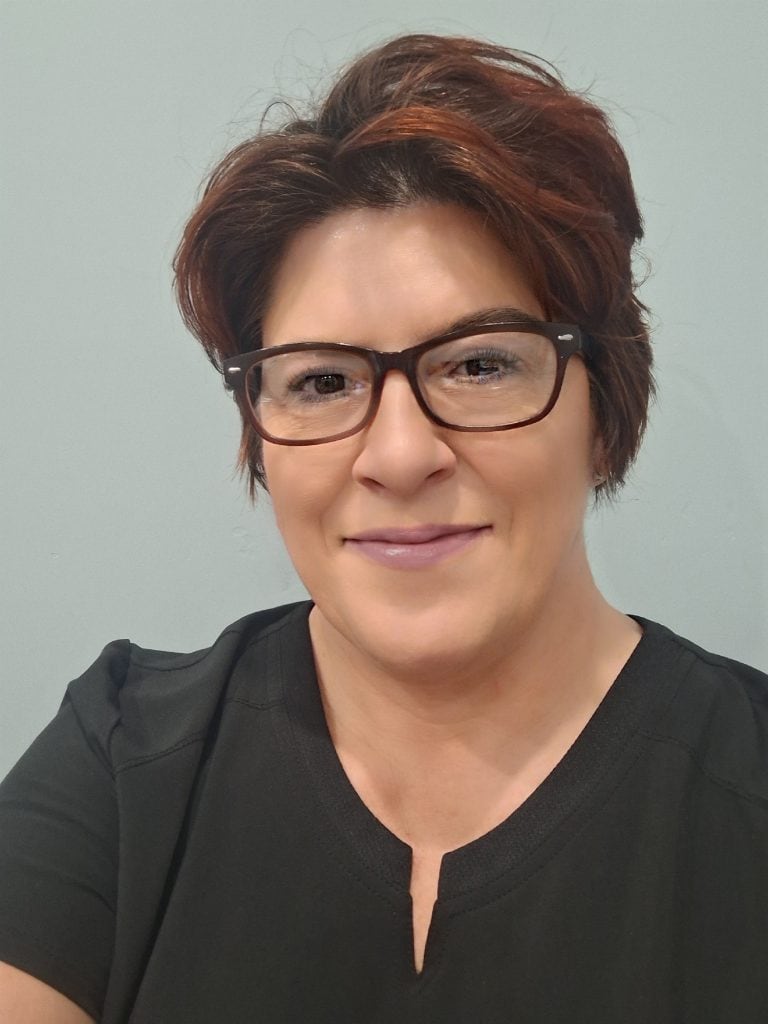 A smiling woman in glasses