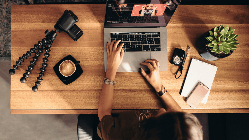 image of professional at a laptop with camera equipment on their desk
