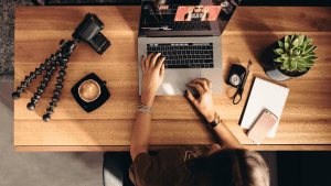 image of professional at a laptop with camera equipment on their desk